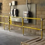 Safety railing installation around high-voltage equipment at ground level of manufacturing facility.