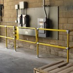 Safety railing installation around high-voltage equipment at ground level of manufacturing facility.