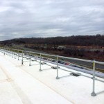 Roof-edge guardrail systems installation using pre-assembled non-penetrating guardrails on rubber-coated rooftop of Fortune 500 technology and electronics company.