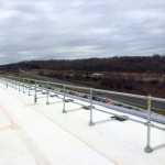 Roof-edge guardrail systems installation using pre-assembled non-penetrating guardrails on rubber-coated rooftop of Fortune 500 technology and electronics company.